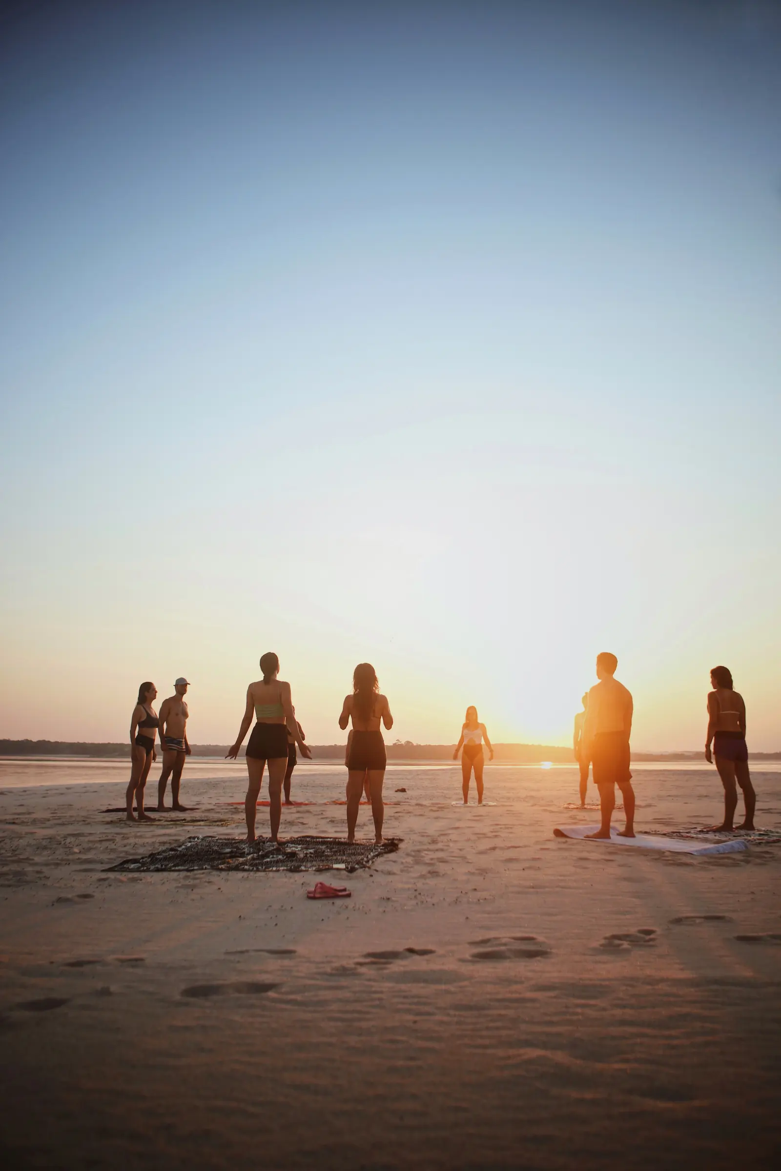 Grupo em silhueta diante do nascer do sol em uma praia do Tapajós
