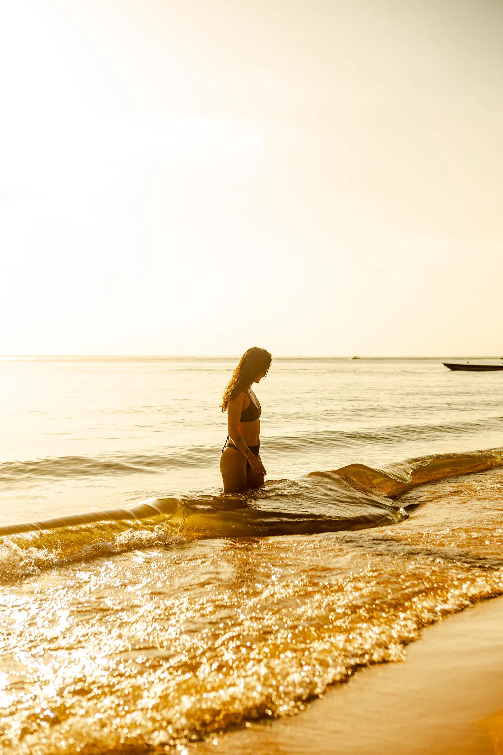 Participante na praia ao pôr do sol
