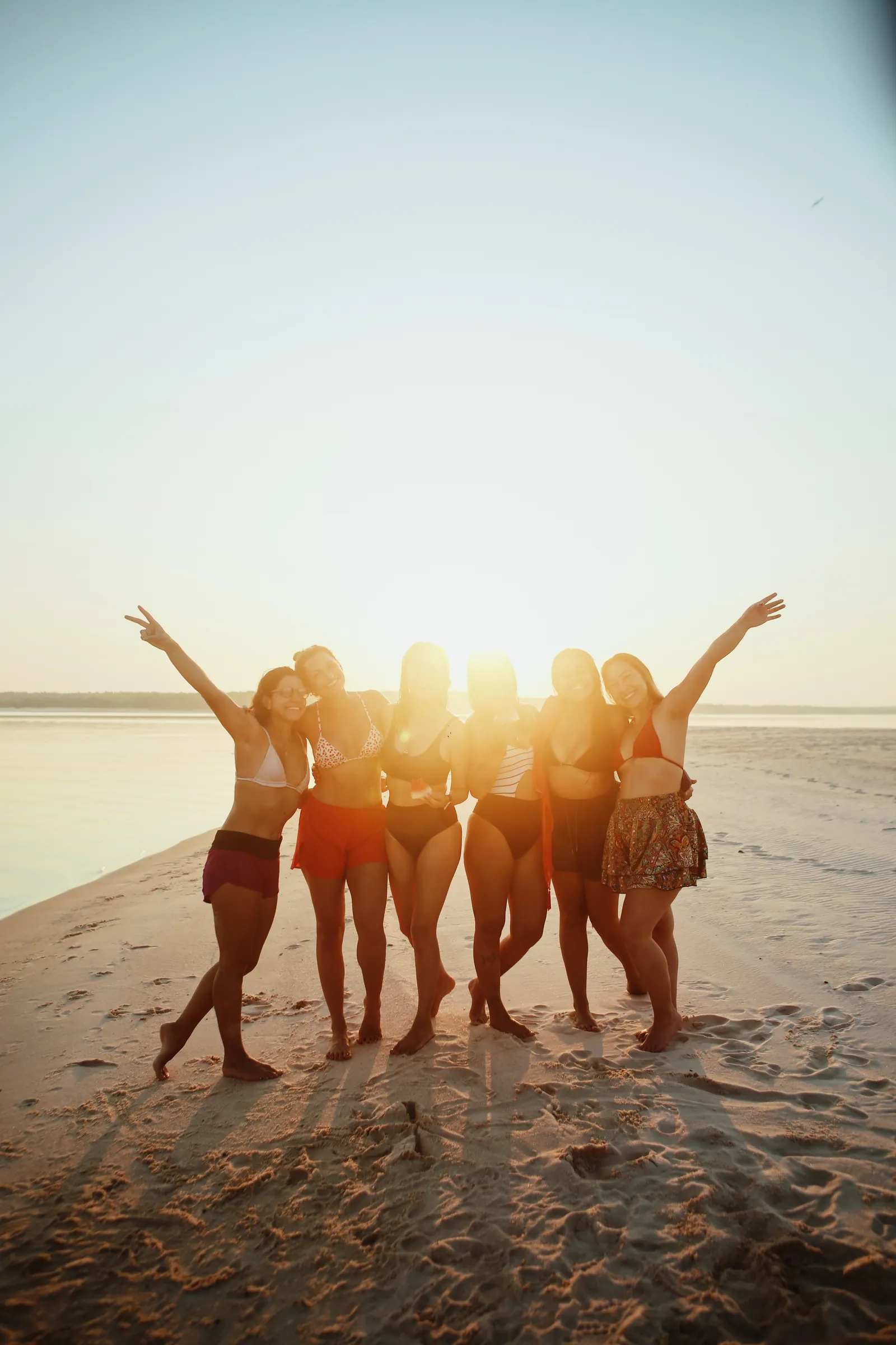 Grupo reunido em uma praia do Tapajós ao pôr do sol