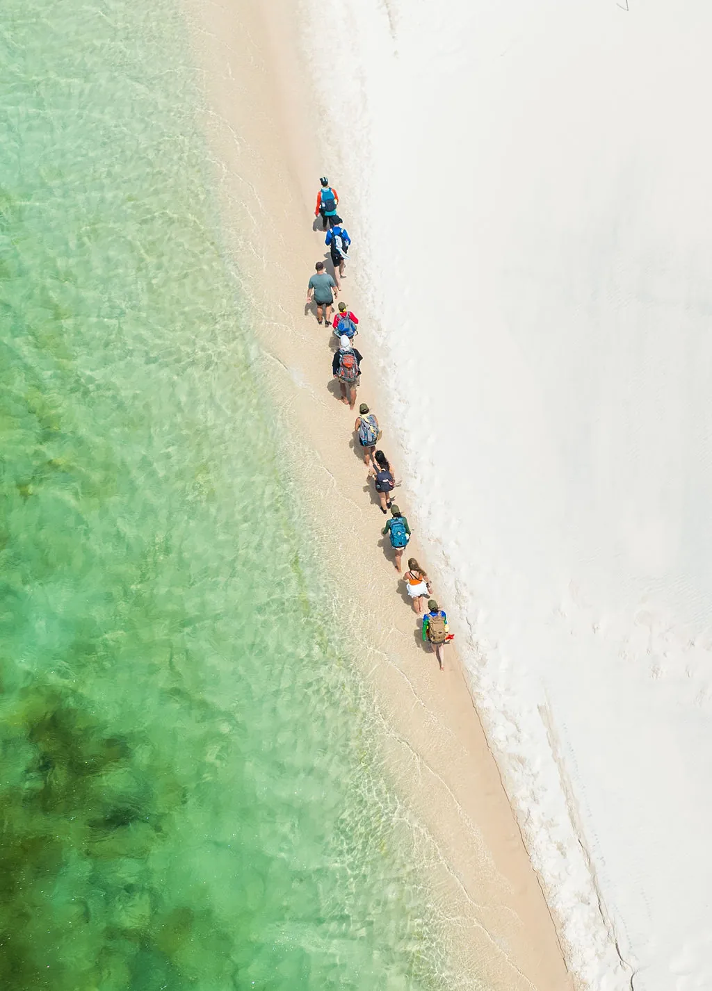 Vista aérea de participantes às margens da lagoa