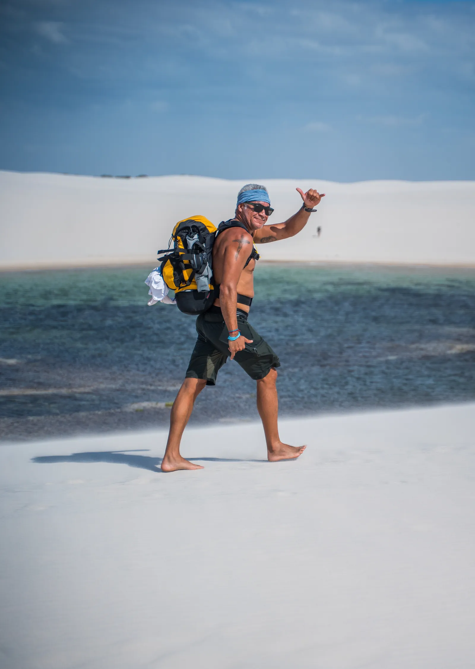 Participante com mochila na areia branca